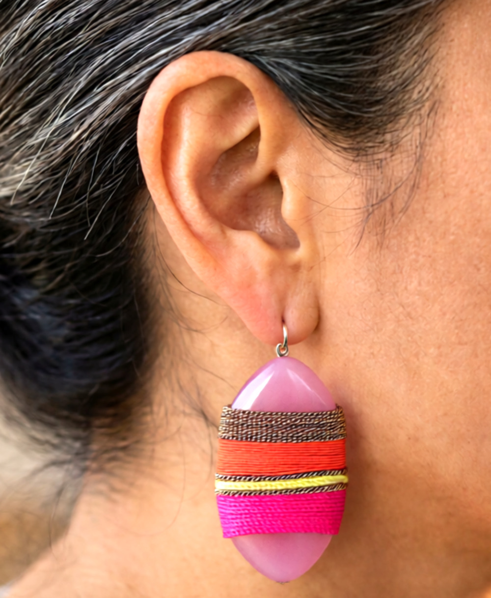Zoë + Syd earrings feature pink teardrop-shaped stones wrapped in vibrant raffia